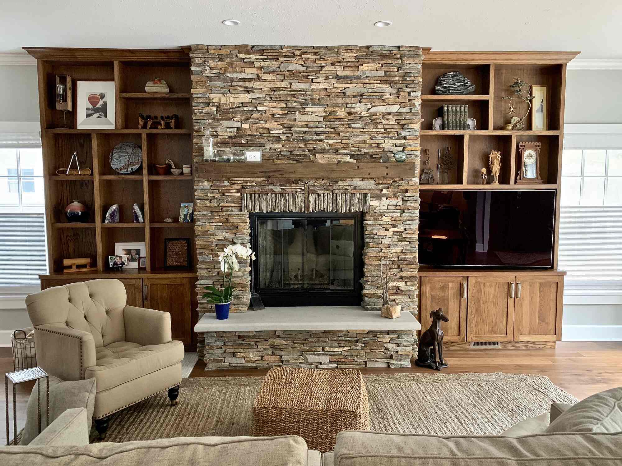 Grand Beach home interior featuring rustic fireplace and built-in entertainment center by Barbour Construction.