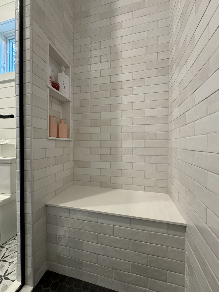 Built-in shower bench with white subway tile in Barbour Construction’s custom home in Buchanan, MI.