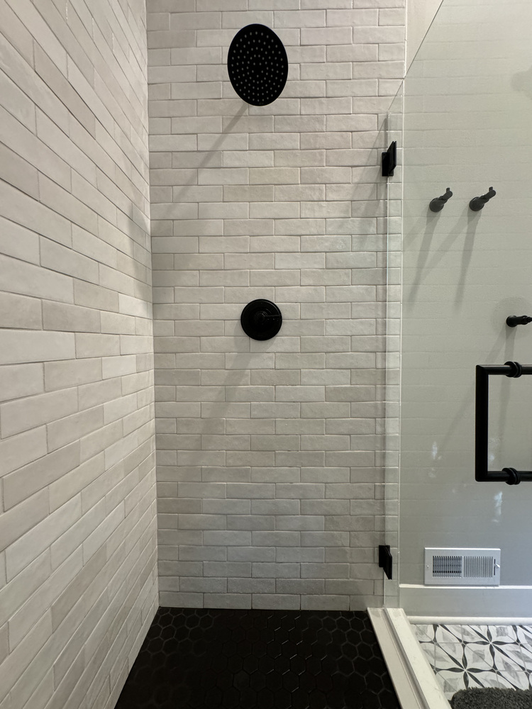 Matte black shower fixtures and white tile in custom bathroom by Barbour Construction, Buchanan, MI.