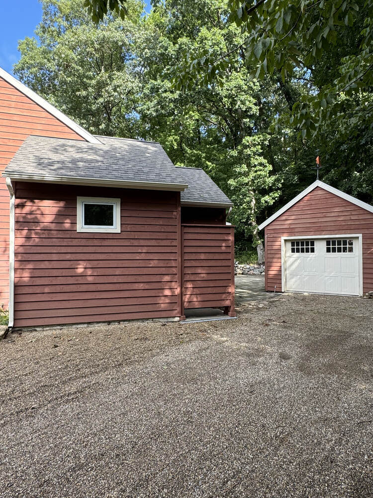 Rear view of custom home exterior and outdoor shower by Barbour Construction in Buchanan, MI.