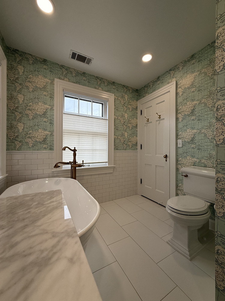 Barbour Construction bathroom with soaking tub, toilet, and globe-themed wallpaper in South Bend, IN
