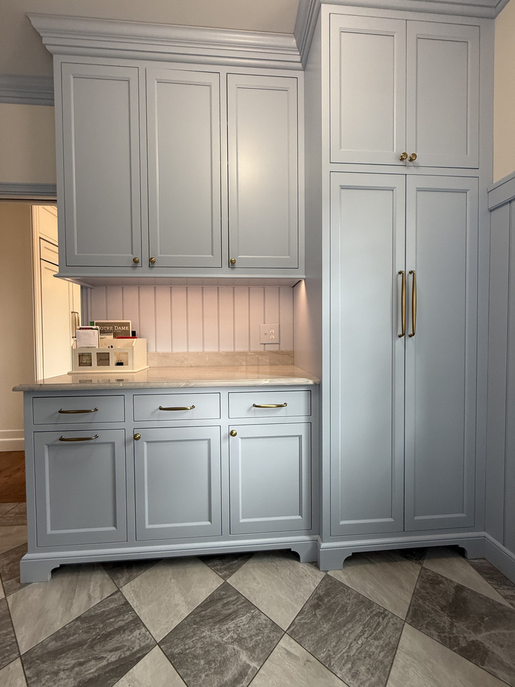 Blue custom cabinetry with marble countertop in South Bend mudroom by Barbour Construction