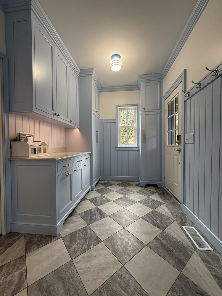 Bright mudroom with blue cabinetry and tile floor in South Bend by Barbour Construction