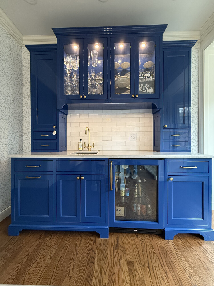 Built-in wet bar with navy blue cabinets and glassware storage by Barbour Construction in South Bend, IN