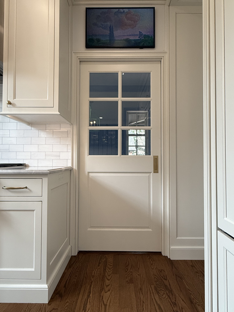 Custom kitchen doorway with windowed door and upper wall decor by Barbour Construction in South Bend, IN