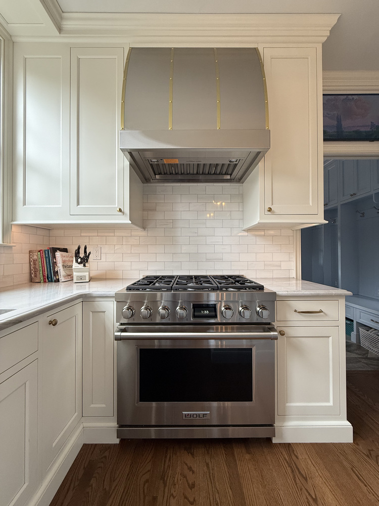 Custom kitchen stove with oversized range hood and white tile backsplash in South Bend by Barbour Construction