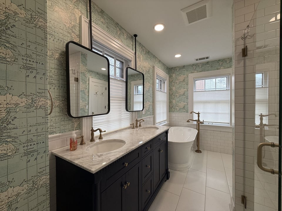 Double vanity bathroom with brass fixtures and vintage-style mirrors by Barbour Construction in South Bend