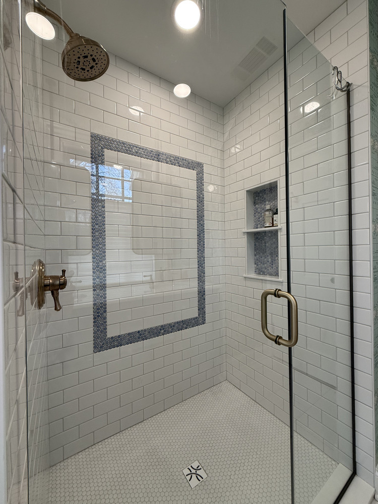 Interior of custom tile shower with hex tile floor and window accent by Barbour Construction in South Bend