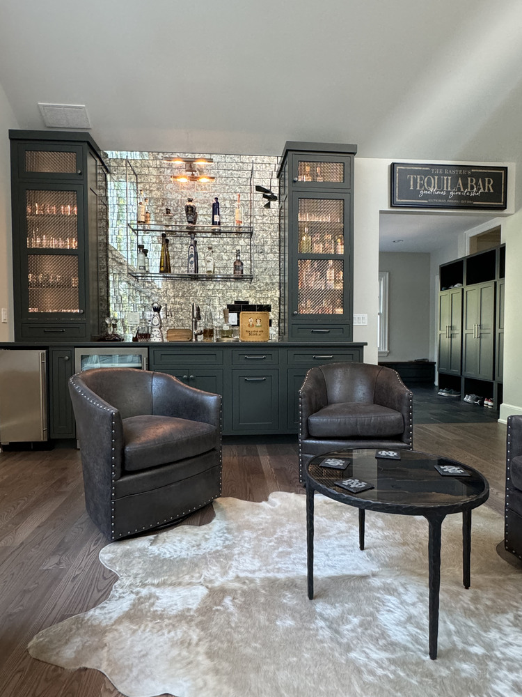 Custom home tequila bar lounge with leather seating and mirrored shelving by Barbour Construction in South Bend, IN.