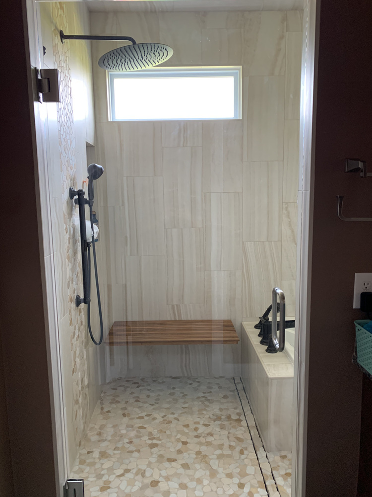 Custom walk-in shower with rainfall showerhead and bench seating by Barbour Construction in South Bend, IN.