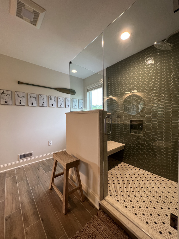 Custom shower with green tile accent wall and wood-look flooring by Barbour Construction in Dowagiac, MI.