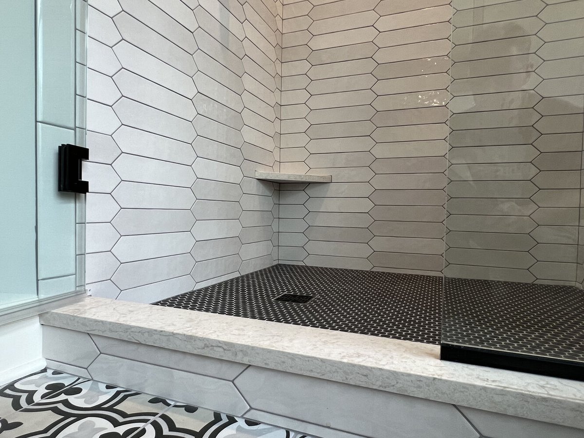 Detail of black hex shower floor and bench in Barbour Construction bathroom project in Dowagiac, MI.