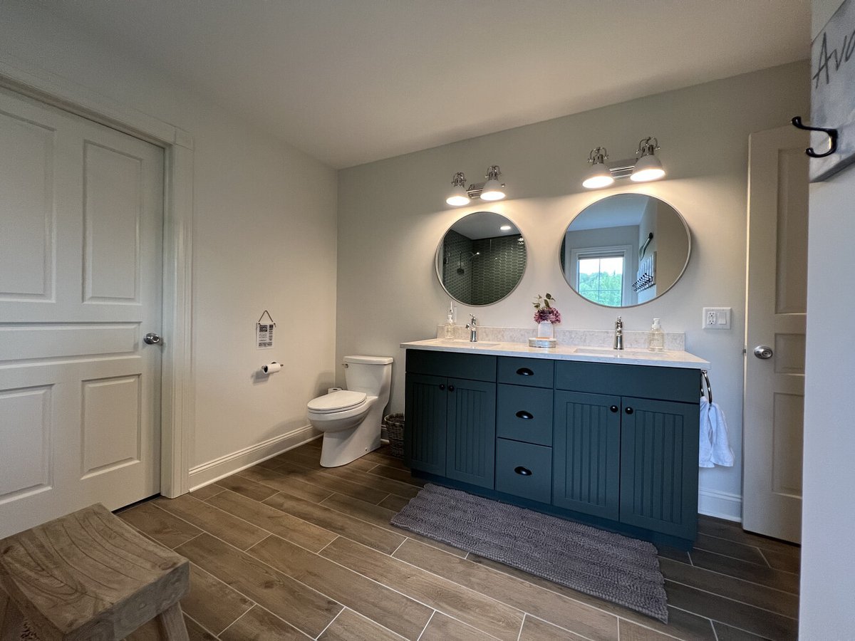 Double sink vanity with round mirrors and toilet in custom bath by Barbour Construction in Dowagiac, MI.