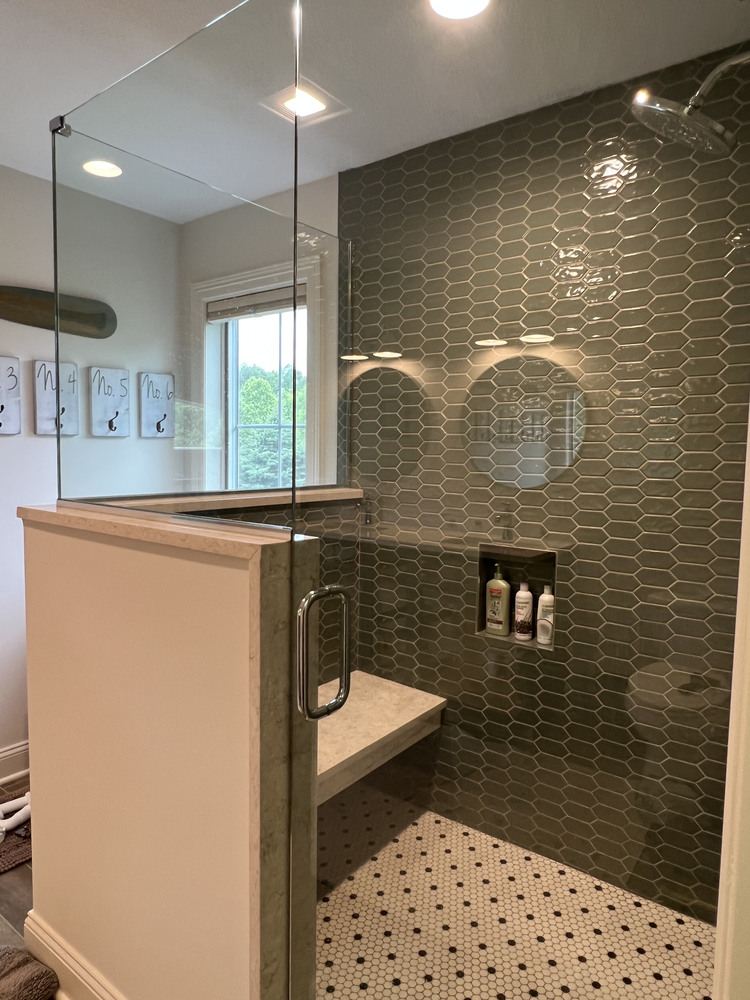 Modern green tiled shower with bench seating in a Dowagiac, MI bathroom remodel by Barbour Construction.