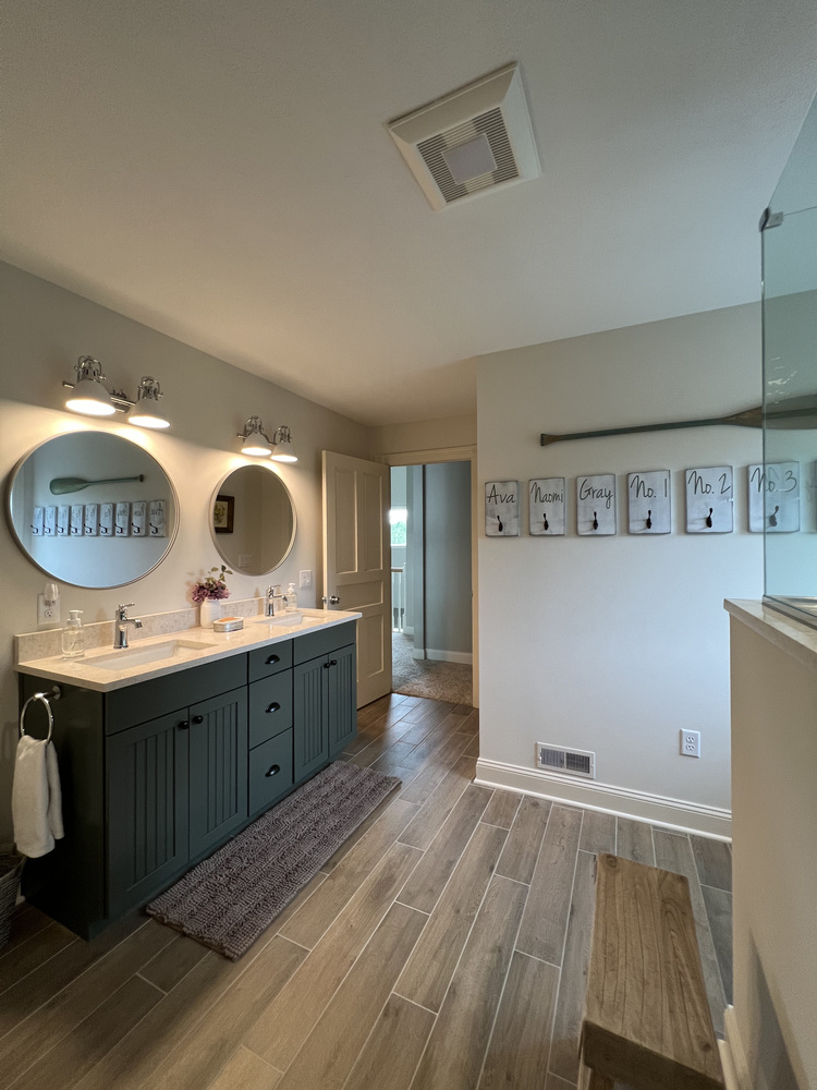 Stylish vanity setup with circular mirrors and soft lighting in a Barbour Construction project in Dowagiac, MI.