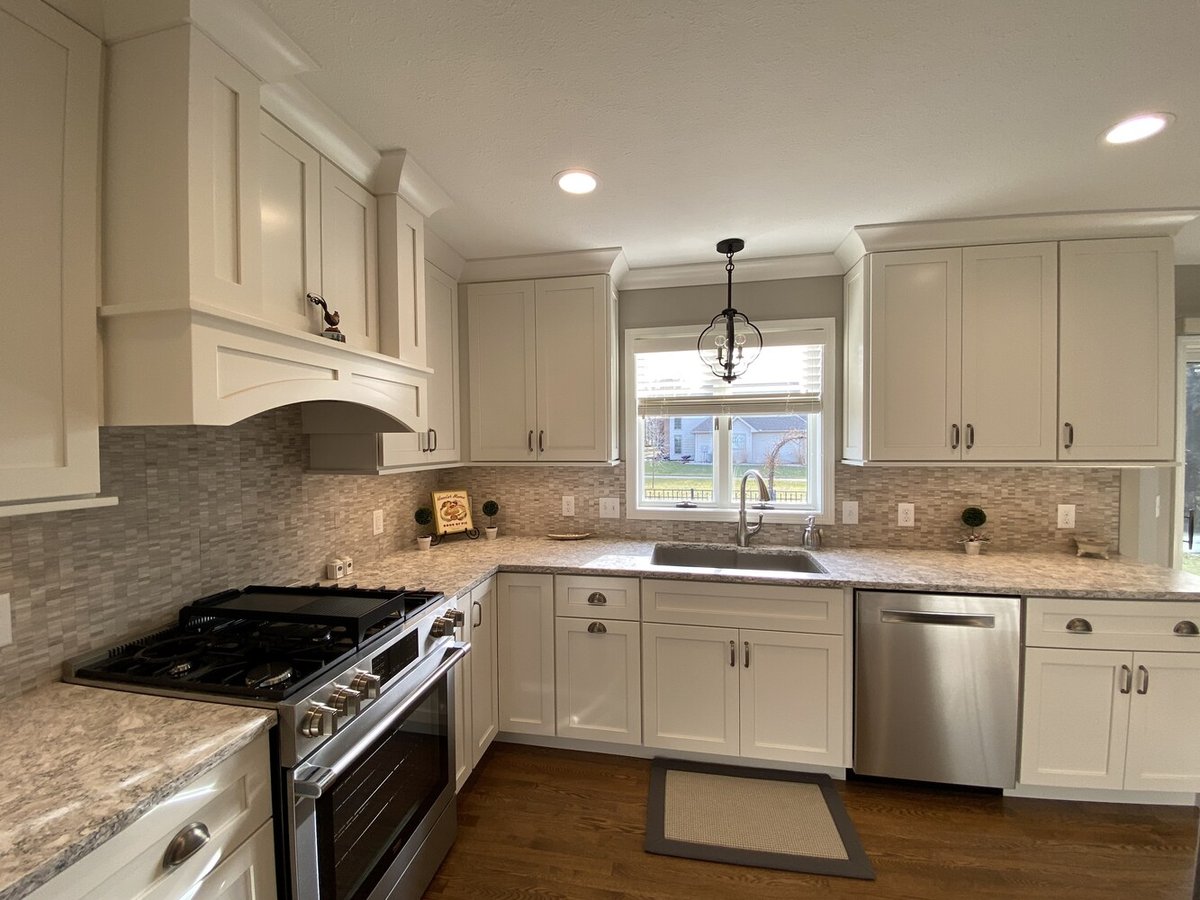 Bright and airy kitchen sink area with pendant light and backsplash by Barbour Construction in Goshen, IN.