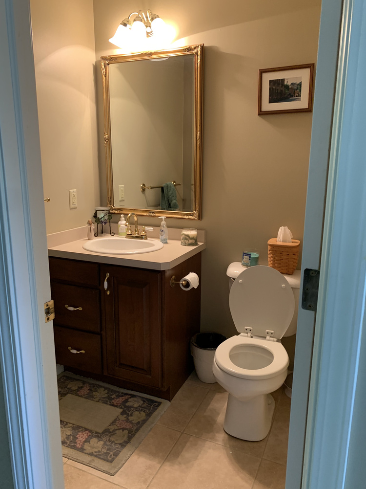 Powder room remodel with bird-pattern wallpaper and gray vanity by Barbour Construction in Goshen, IN.