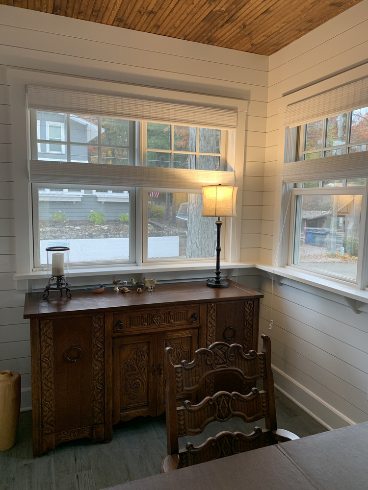 Cozy corner with carved wood furniture and shiplap walls in a Grand Beach custom home by Barbour Construction.