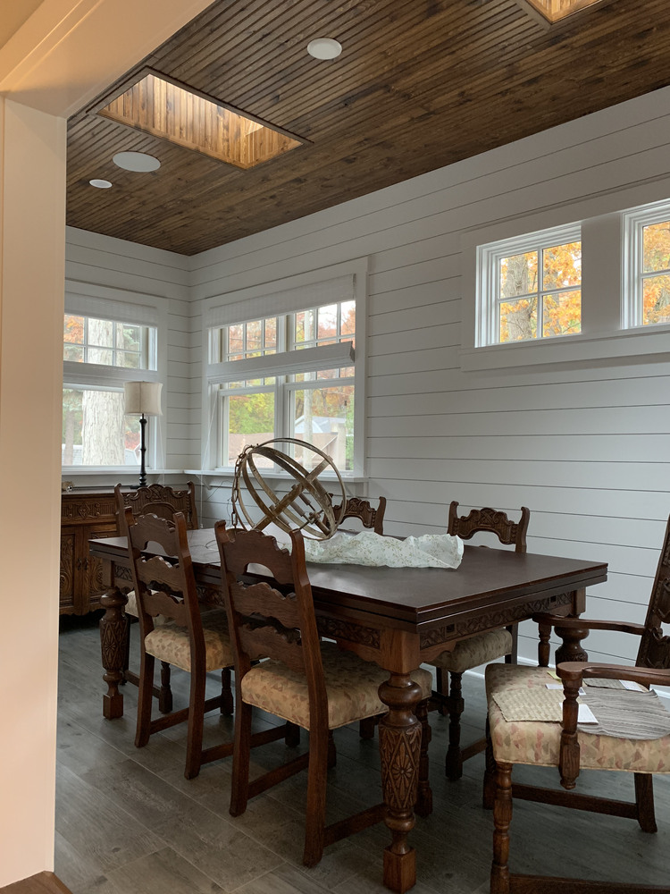 Dining area with ornate wood table and ceiling skylights in a Grand Beach custom home by Barbour Construction.