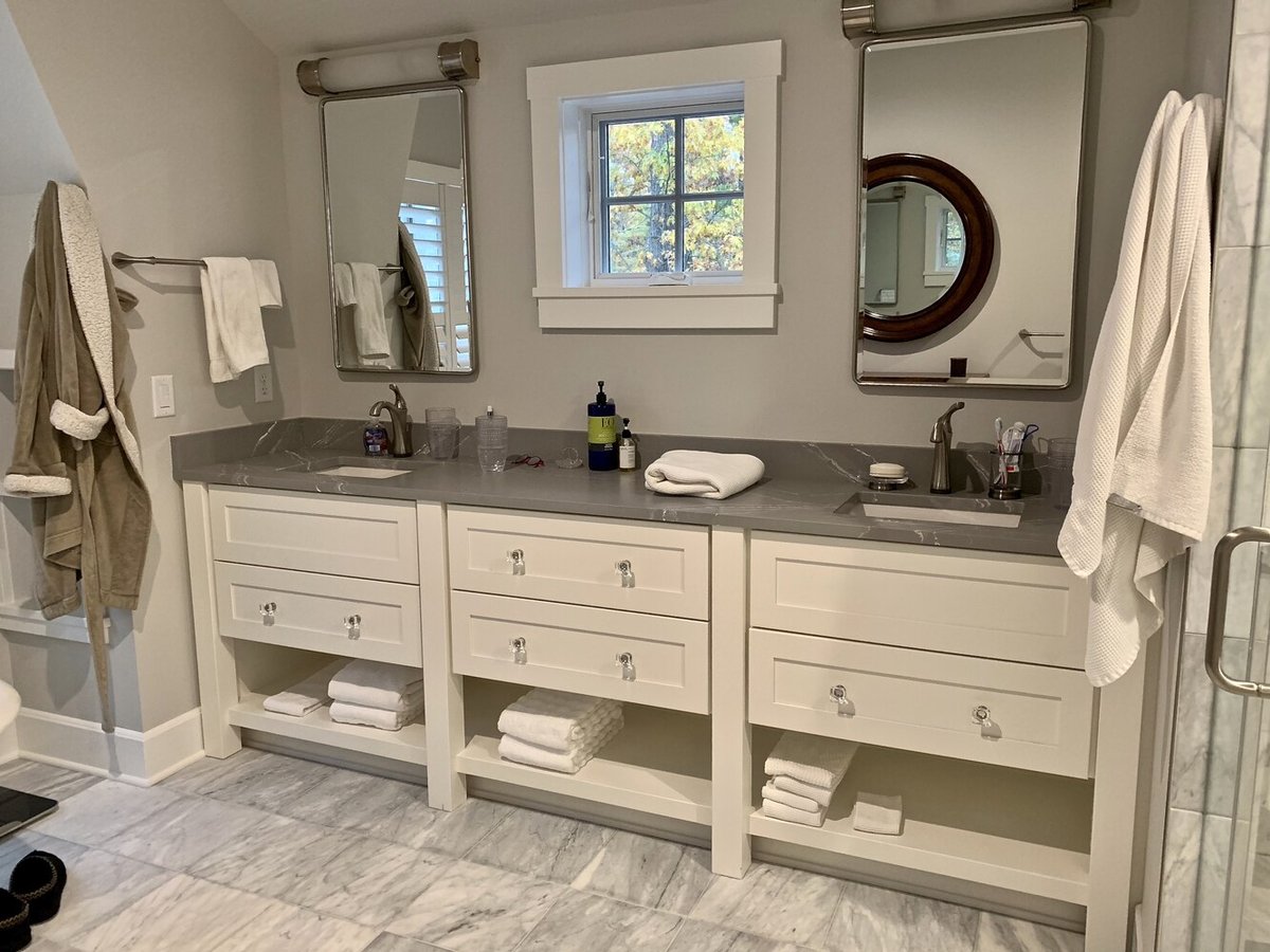 Dual-sink custom bathroom vanity with marble flooring by Barbour Construction in Grand Beach, MI.