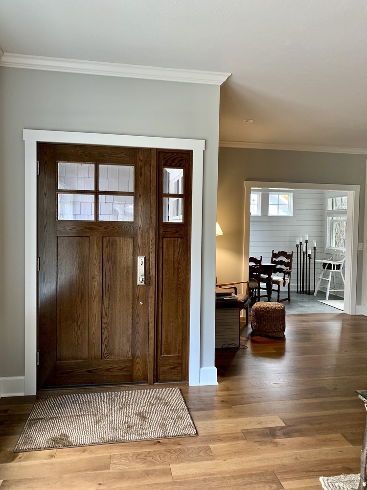 Grand Beach custom home entryway with solid wood front door by Barbour Construction.