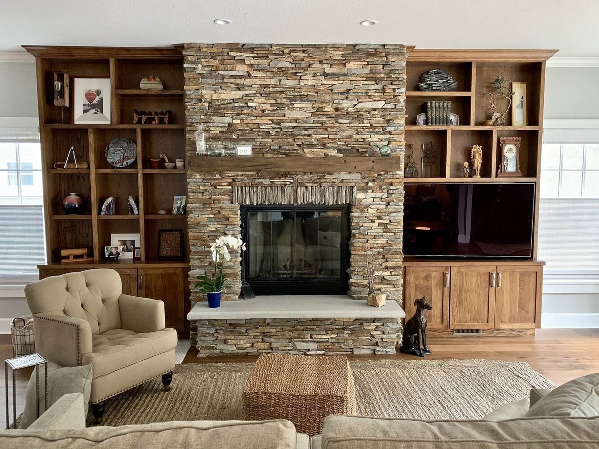 Grand Beach home interior featuring rustic fireplace and built-in entertainment center by Barbour Construction.