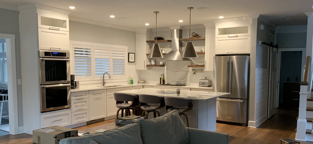 Open-concept kitchen featuring marble countertops and modern fixtures in Grand Beach custom home by Barbour Construction.