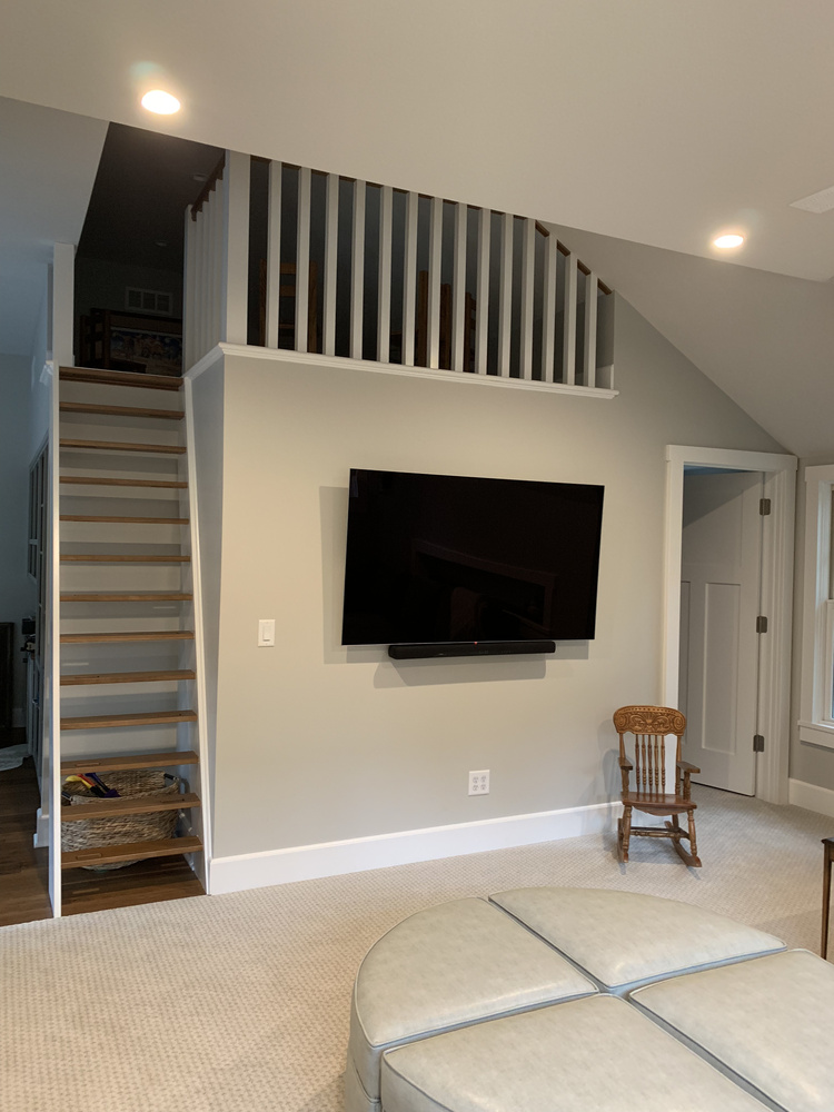 Open-concept loft with wall-mounted television in a Grand Beach custom home by Barbour Construction.
