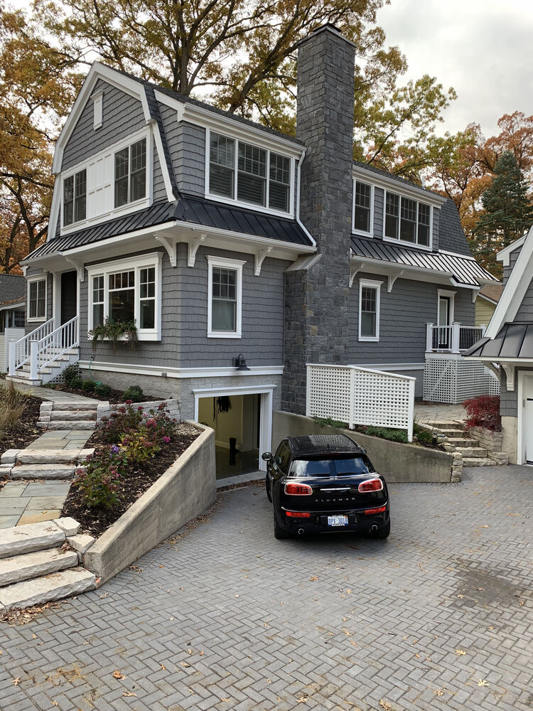 Two-story custom home with paver driveway and detached garage by Barbour Construction in Grand Beach, MI.