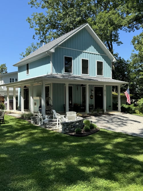 Blue board and batten custom home exterior with covered porch by Barbour Construction in Grand Beach, MI.
