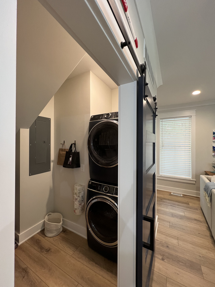 Compact laundry nook with stacked washer and dryer by Barbour Construction in Grand Beach, MI.