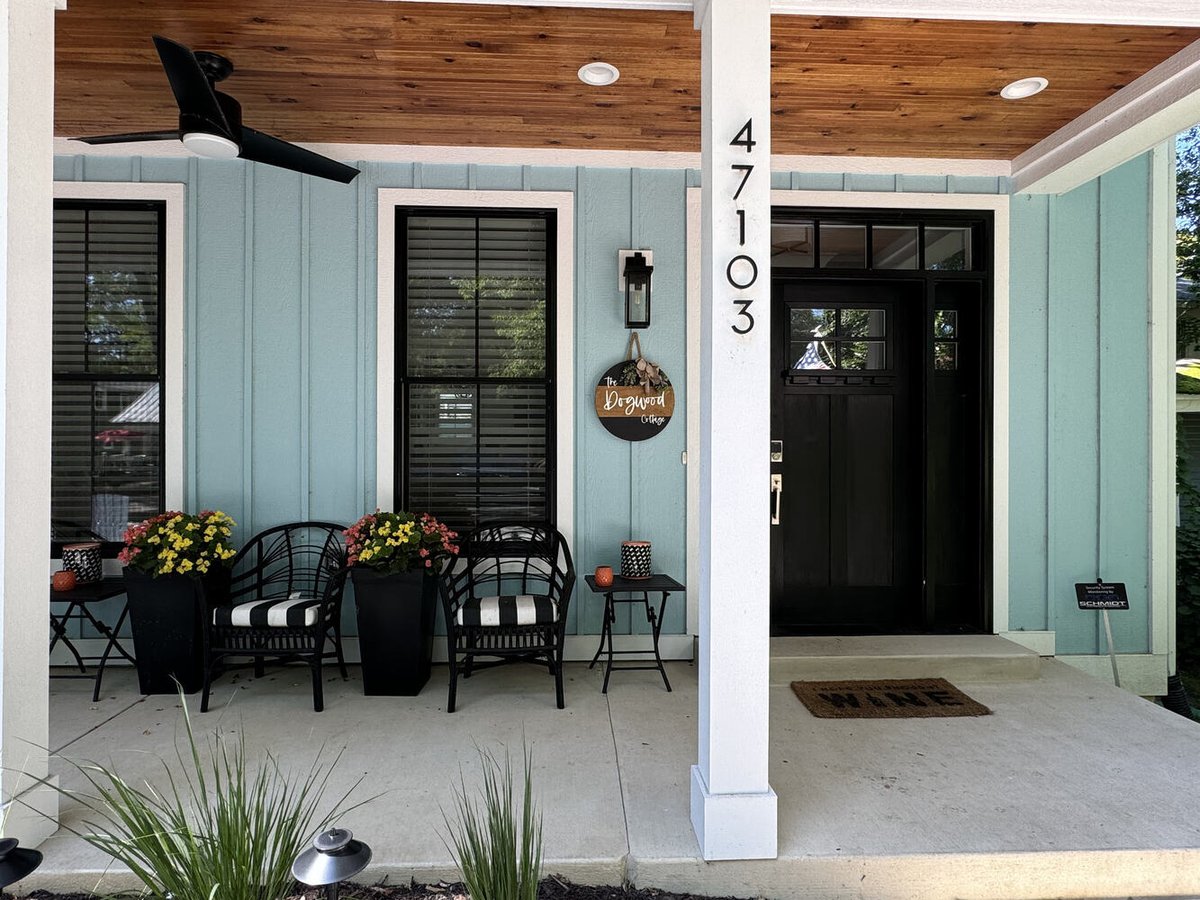 Custom home front entrance with wood ceiling and modern black door in Grand Beach by Barbour Construction.