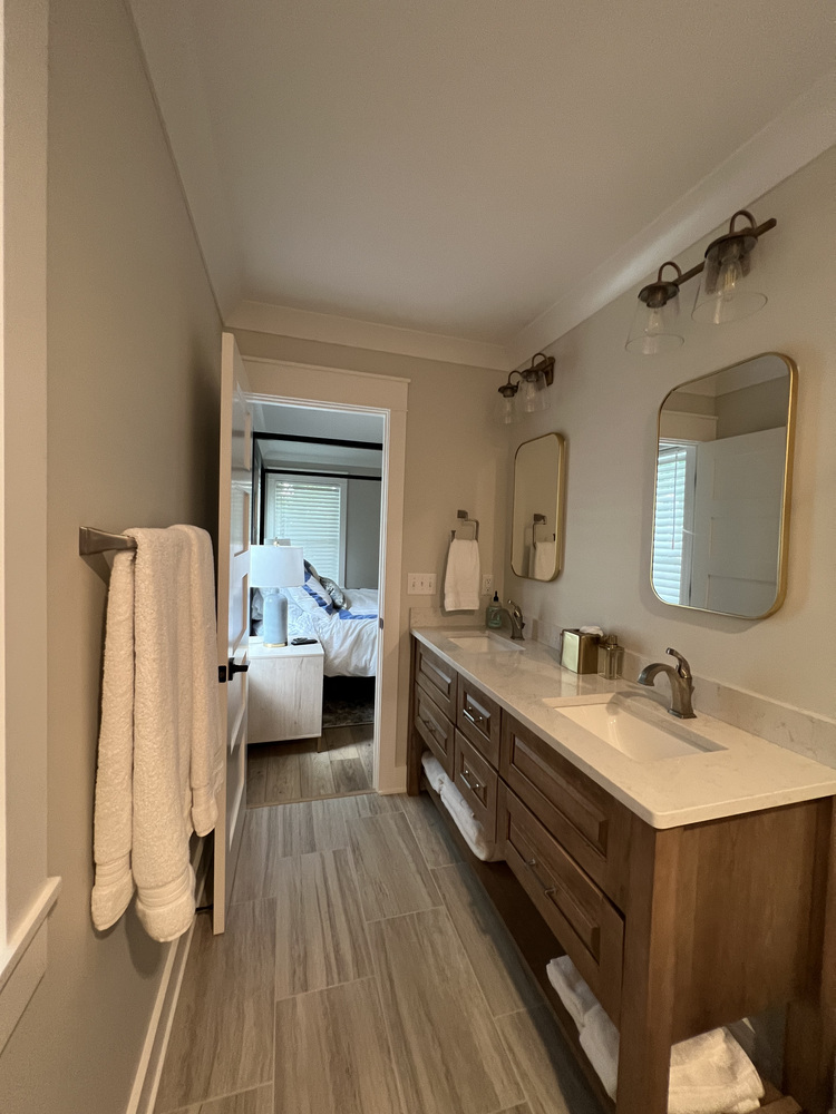 Grand Beach bathroom hallway with view into master bedroom, designed by Barbour Construction.