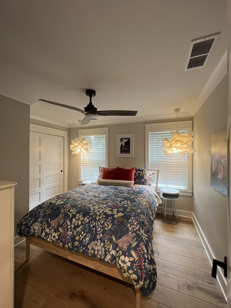 Grand Beach custom bedroom featuring patterned duvet and ceiling fan, built by Barbour Construction.