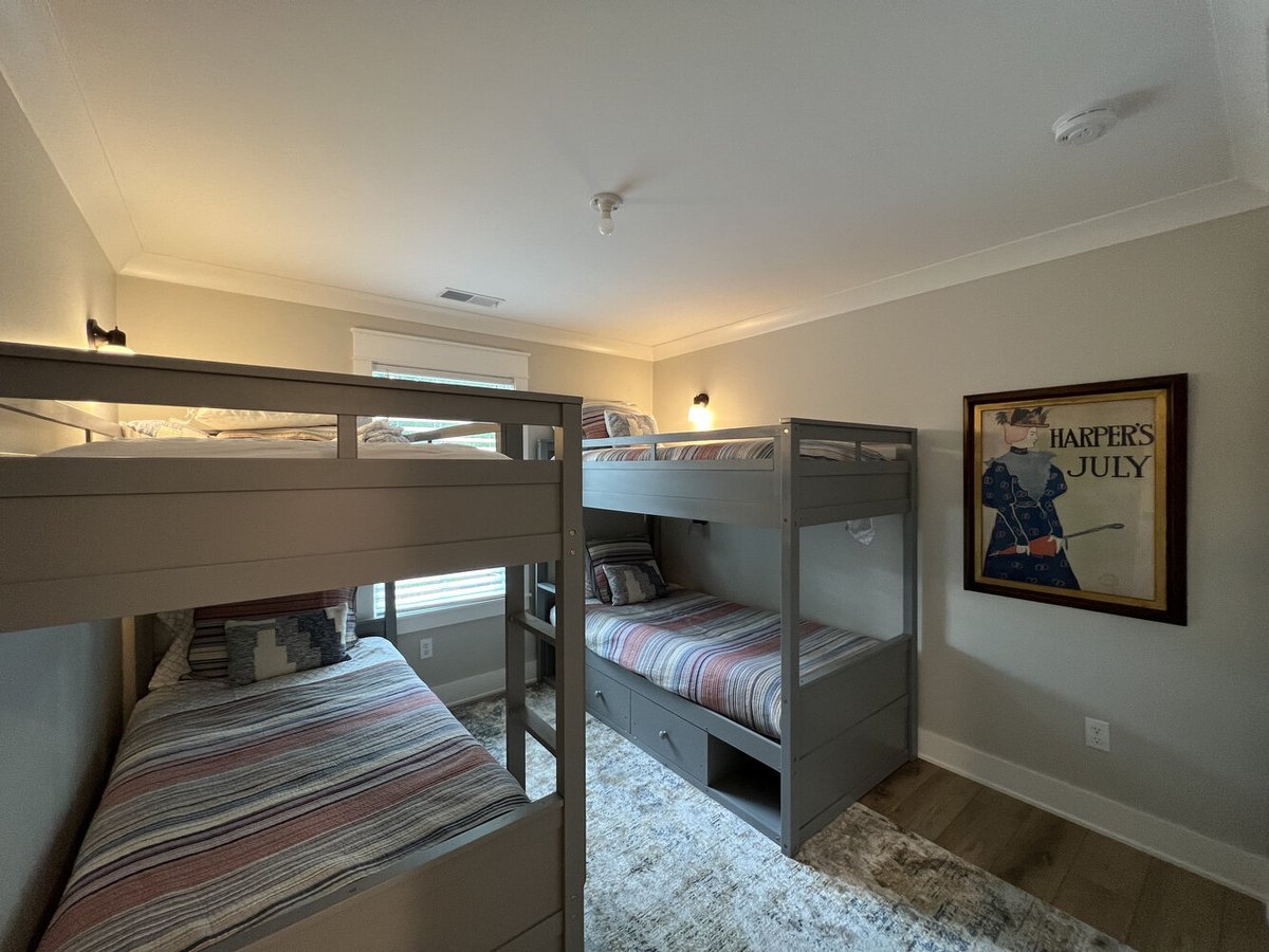 Grand Beach custom bunk room with twin beds and framed artwork by Barbour Construction.