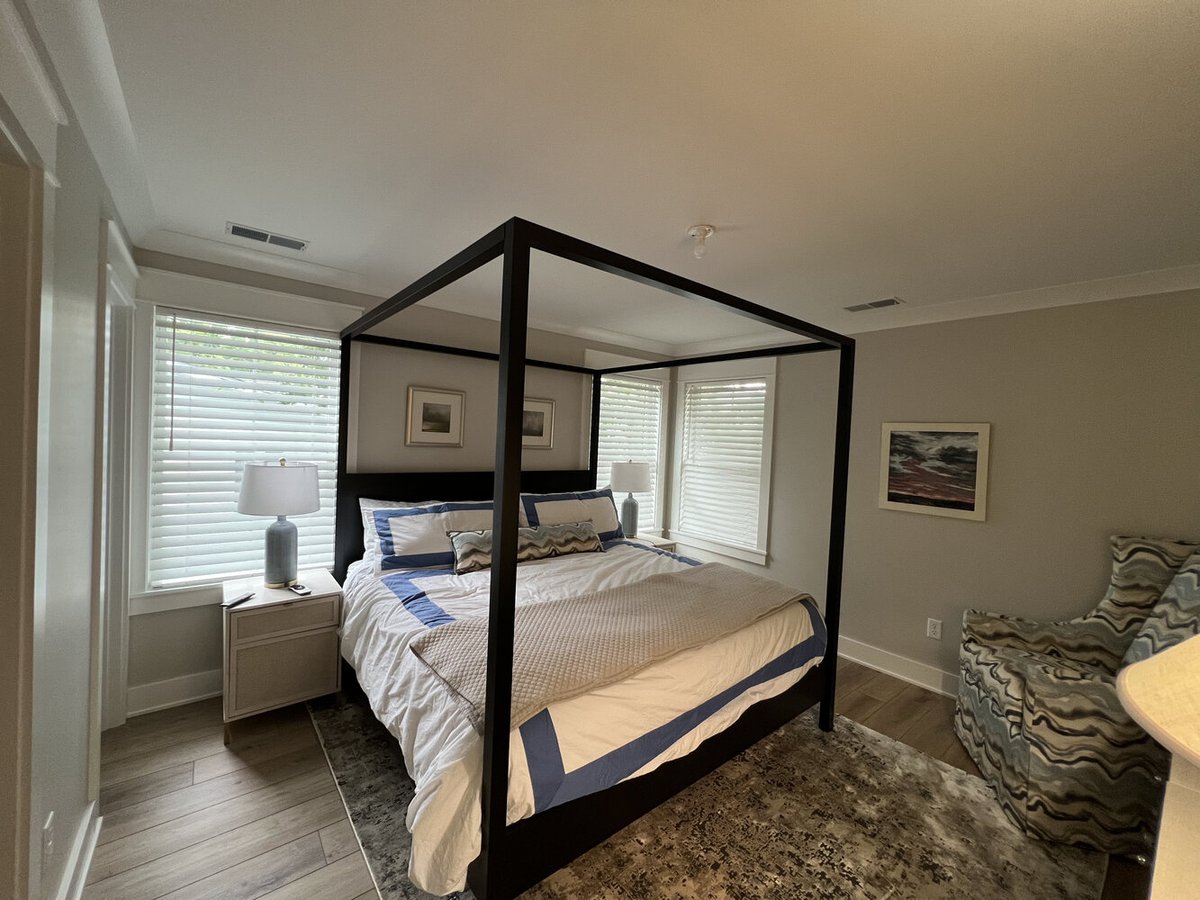 Primary bedroom with canopy bed and large windows by Barbour Construction in Grand Beach, MI.