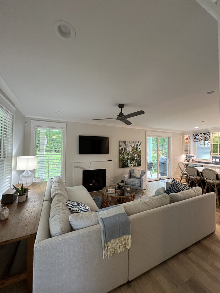 Spacious custom living room with TV and neutral decor in Grand Beach by Barbour Construction.