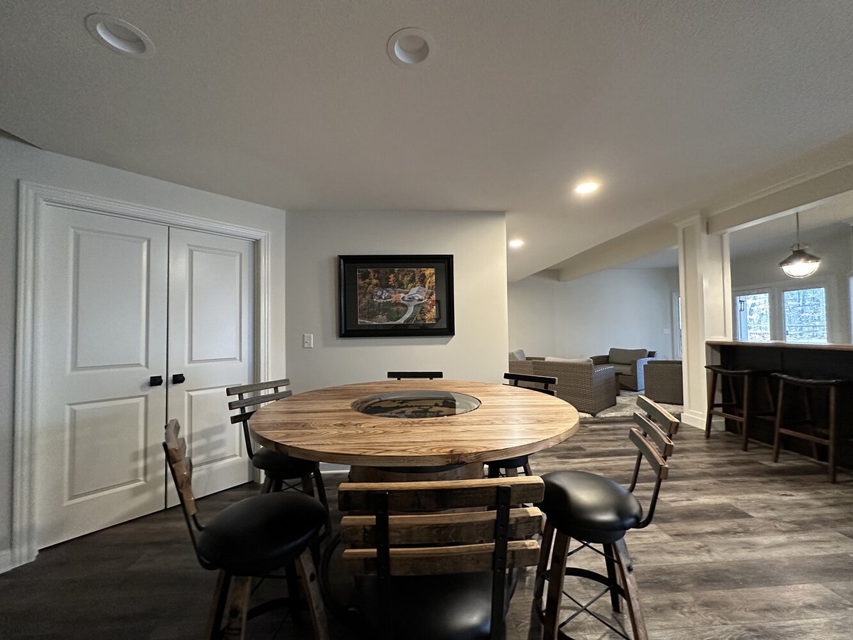 Basement dining and lounge area with rustic wood furniture in custom home by Barbour Construction in New Carlisle, IN.