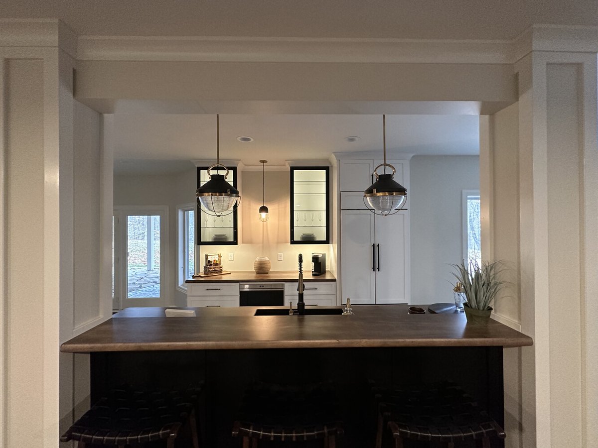 Built-in bar area with pendant lighting and white cabinetry in New Carlisle home by Barbour Construction.