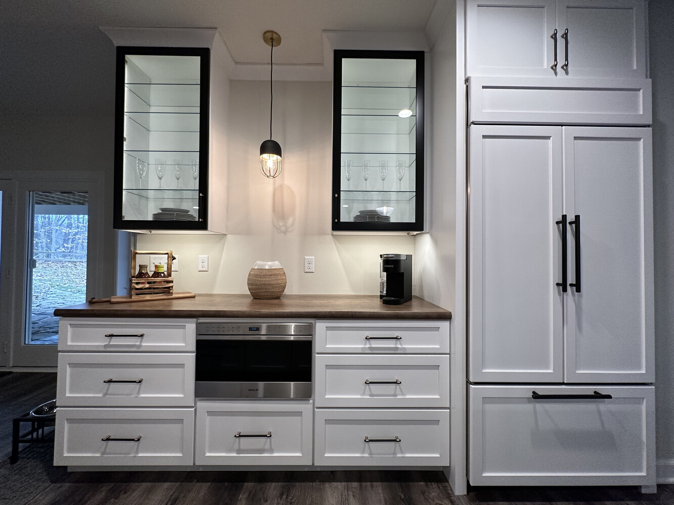 Built-in kitchenette with wood countertops and modern lighting in New Carlisle custom home by Barbour Construction.