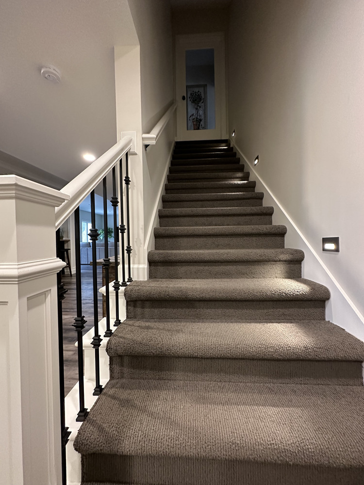 Carpeted staircase with iron spindles in New Carlisle custom home by Barbour Construction.