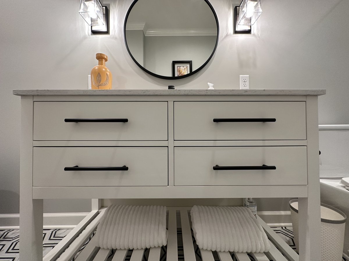 Close-up of white bathroom vanity with black handles in custom New Carlisle home by Barbour Construction.