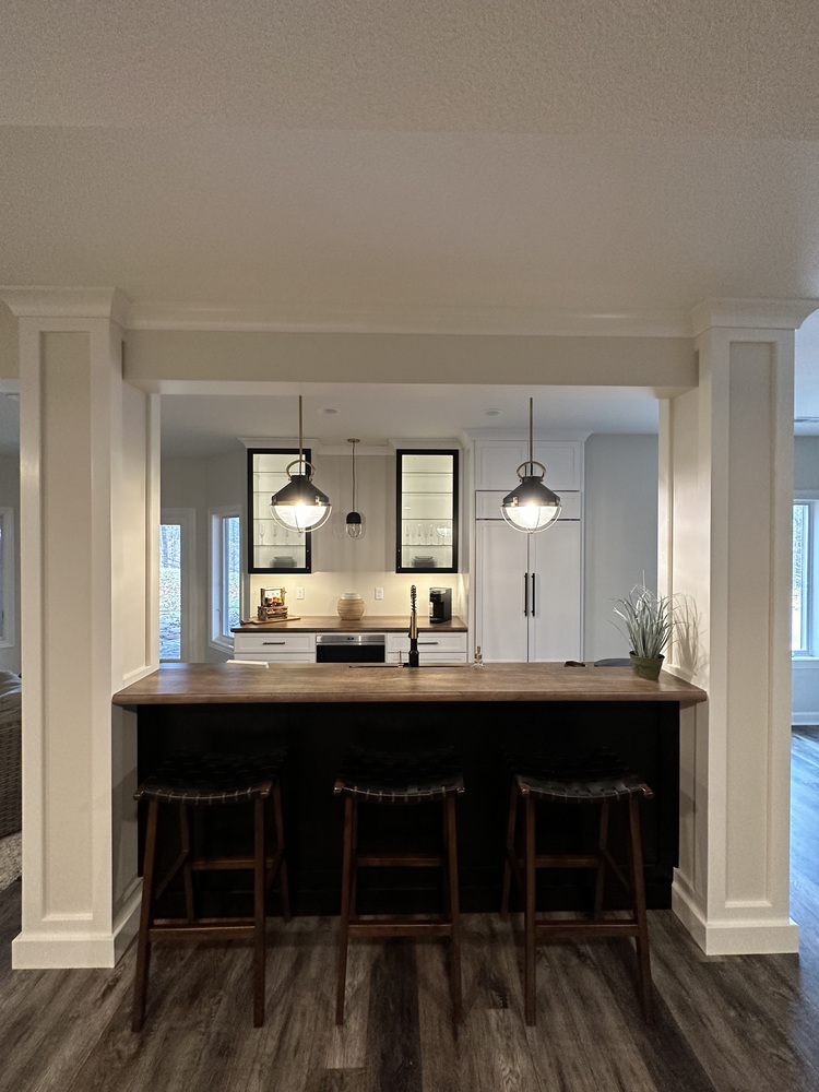 Custom home bar with pendant lighting and wood countertop by Barbour Construction in New Carlisle, IN.