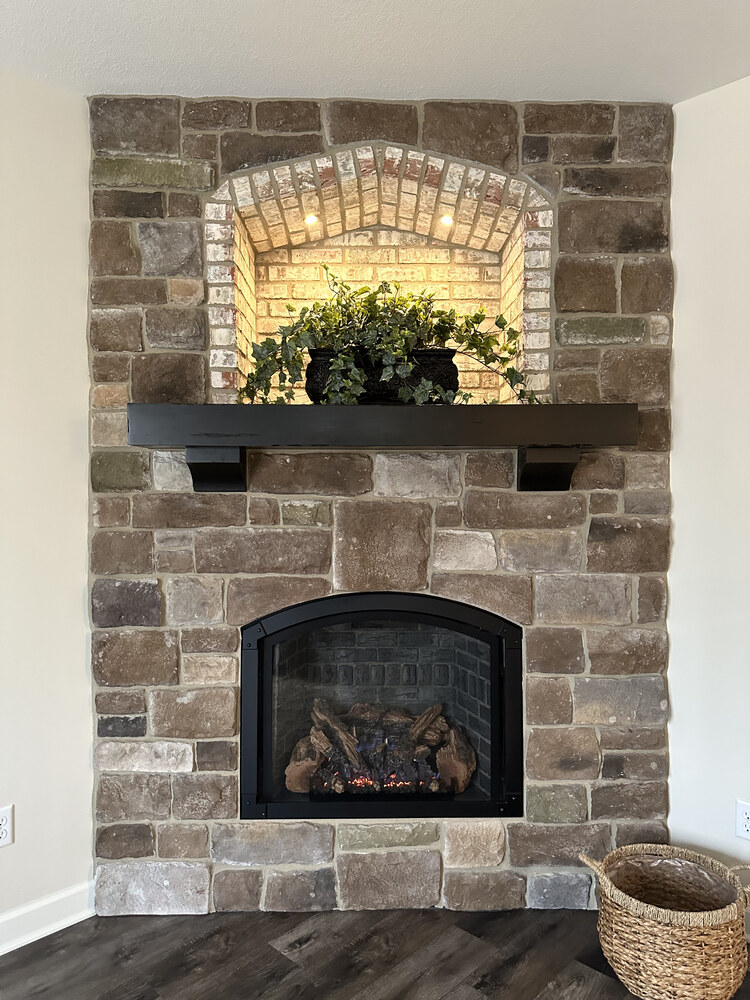 Stone fireplace with wood mantel and built-in niche in a Barbour Construction custom home in New Carlisle, IN.