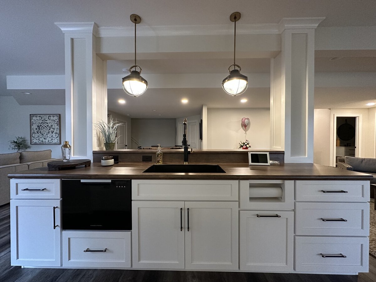 Wet bar with pendant lighting and black undermount sink in New Carlisle home by Barbour Construction.
