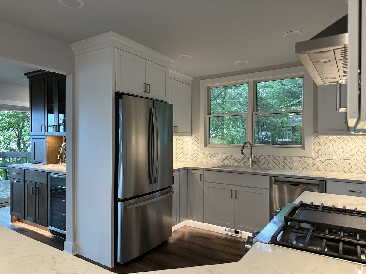 Kitchen detail showing stainless refrigerator and built-in bar area by Barbour Construction in Sawyer, MI.