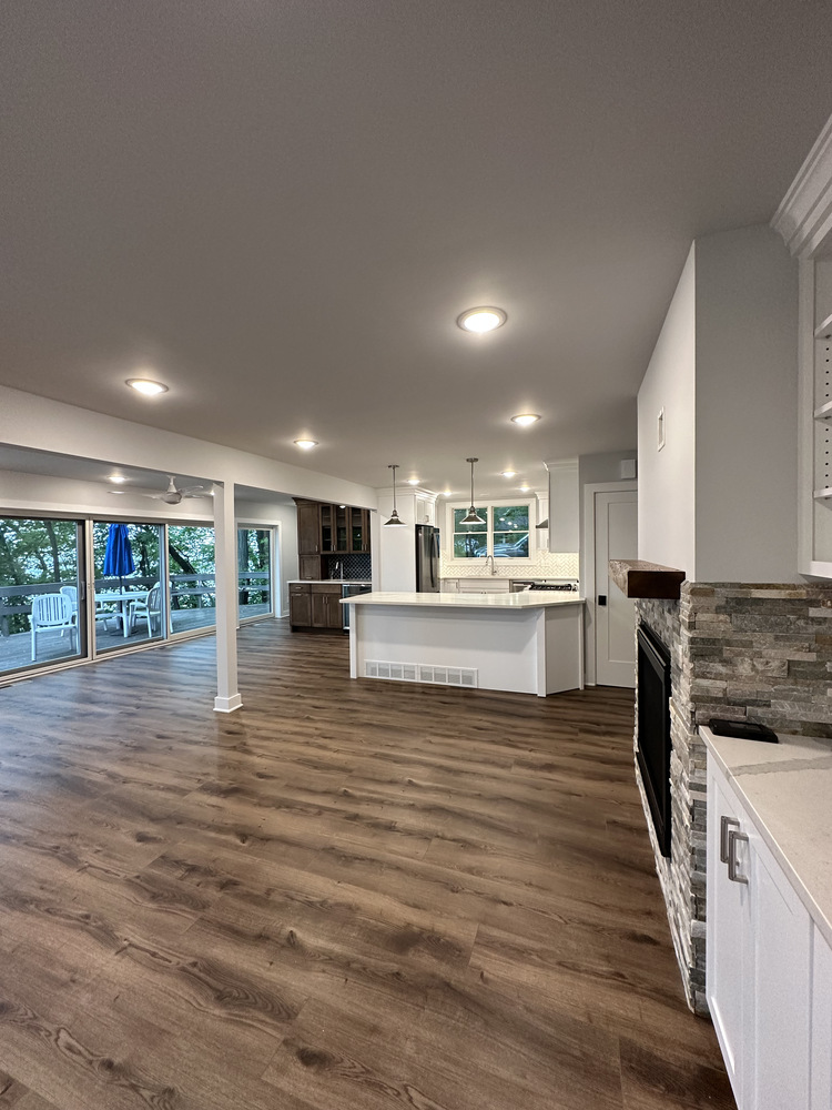 Spacious open living area with large kitchen island and outdoor views in Sawyer, MI home by Barbour Construction.