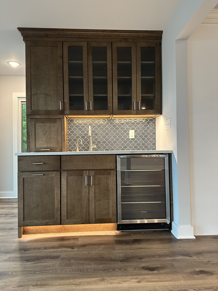 View of wet bar and kitchen layout with dual backsplash styles in Sawyer, MI home by Barbour Construction.