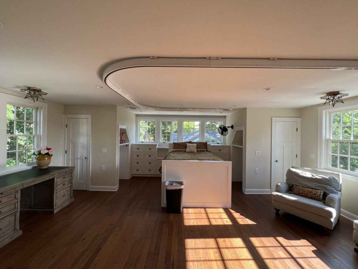 Bright bedroom with built-in storage and curved ceiling track by Barbour Construction in South Bend, IN.