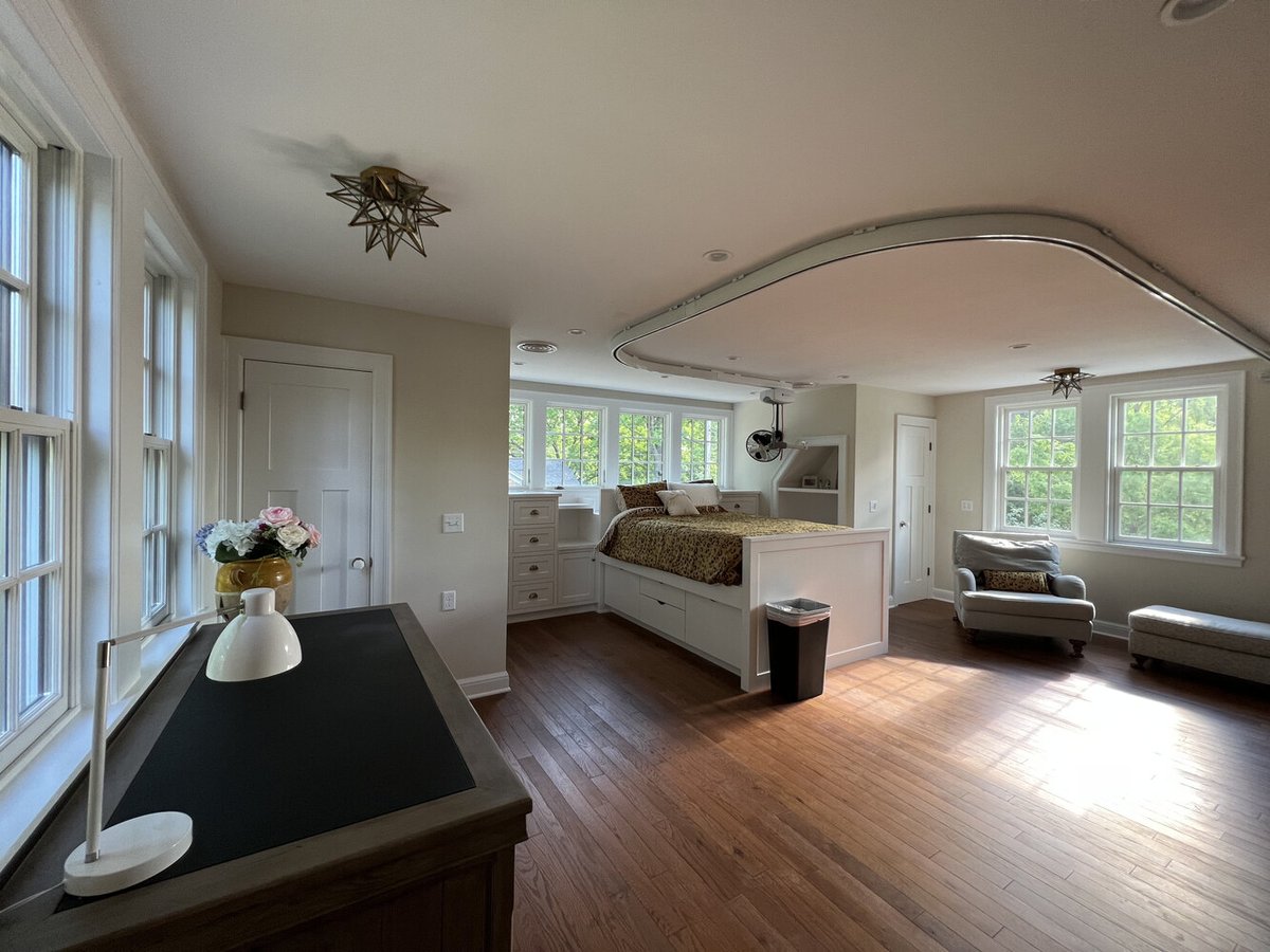 Bright custom bedroom with hardwood flooring and large windows by Barbour Construction in South Bend, IN.